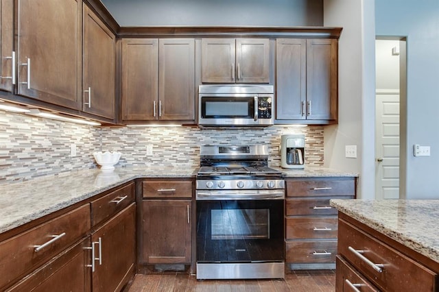 9124 NW 90th Cir, Yukon, OK 73099 - kitchen with appliances with stainless steel finishes, dark wood finished floors, light stone counters, decorative backsplash, and dark brown cabinets