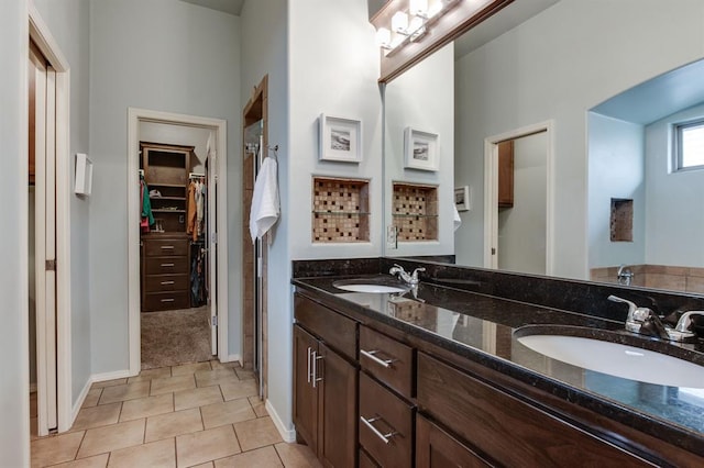 9124 NW 90th Cir, Yukon, OK 73099 - bathroom featuring double vanity, a spacious closet, and tile patterned flooring