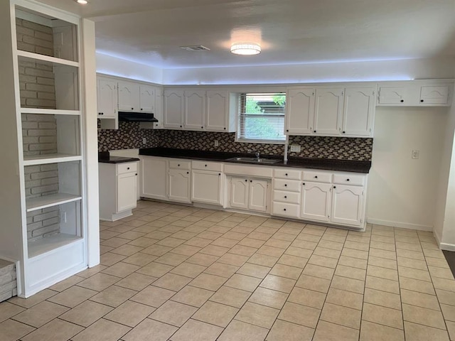 2928 N Downing Ave, Bethany, OK 73008 - kitchen featuring dark countertops, backsplash, white cabinets, and under cabinet range hood