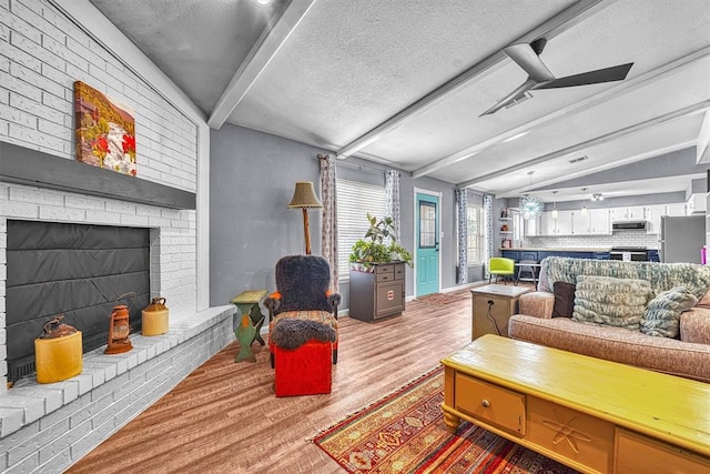 224 N Quail Run, Altus, OK 73521 - living area featuring wood finished floors, a textured ceiling, and a brick fireplace