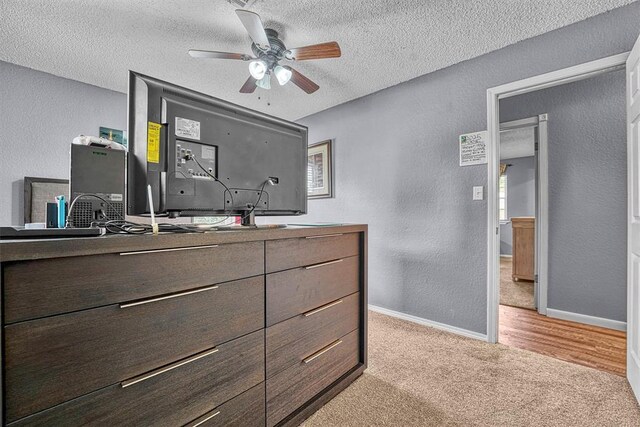 224 N Quail Run, Altus, OK 73521 - bedroom featuring a textured wall, a textured ceiling, light carpet, and a ceiling fan