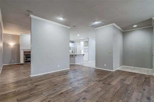 1900 NW 159th Pl, Edmond, OK 73013 - empty room with crown molding, wood finished floors, a fireplace with raised hearth, and recessed lighting