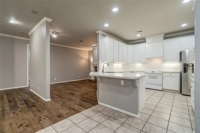 1900 NW 159th Pl, Edmond, OK 73013 - kitchen with electric range, stainless steel fridge, ornamental molding, decorative backsplash, and a breakfast bar