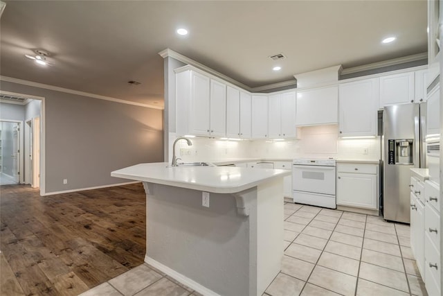 1900 NW 159th Pl, Edmond, OK 73013 - kitchen featuring white range with electric cooktop, stainless steel fridge, a peninsula, ornamental molding, and tasteful backsplash