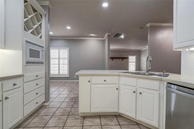 1900 NW 159th Pl, Edmond, OK 73013 - kitchen featuring dishwasher, ornamental molding, white microwave, light tile patterned floors, and a peninsula