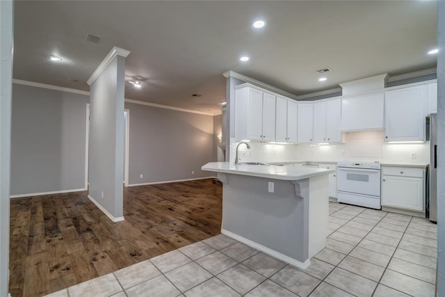 1900 NW 159th Pl, Edmond, OK 73013 - kitchen featuring white range with electric stovetop, crown molding, tasteful backsplash, a peninsula, and light countertops