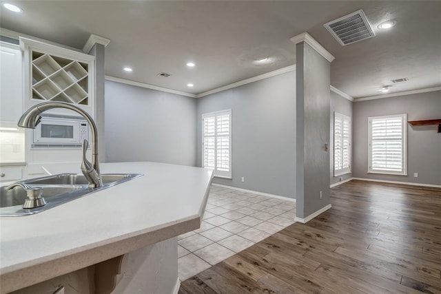 1900 NW 159th Pl, Edmond, OK 73013 - kitchen with ornamental molding, recessed lighting, healthy amount of natural light, light wood-style flooring, and light countertops