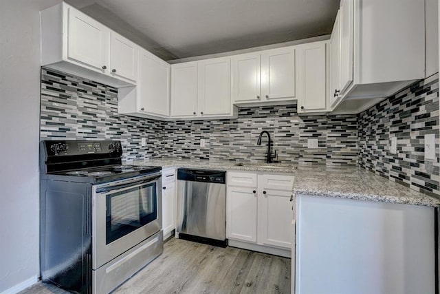 2132 N Rhode Island Ave, Oklahoma City, OK 73111 - kitchen with stainless steel appliances, light wood-type flooring, decorative backsplash, and white cabinets