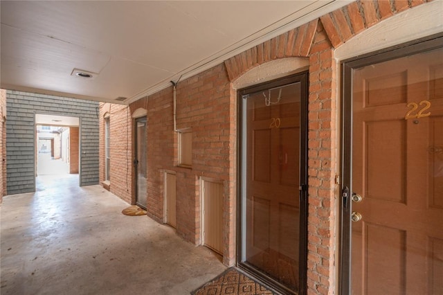 6100 N Brookline Ave Unit 20, Oklahoma City, OK 73112 - hall with brick wall and concrete flooring