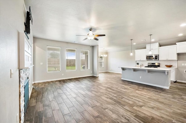 2020 Sara Vista Dr, Yukon, OK 73099 - kitchen featuring stainless steel appliances, ceiling fan, open floor plan, light countertops, and wood finished floors