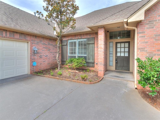 112 Lakeview Ct, Edmond, OK 73003 - entrance to property featuring brick siding, a shingled roof, and driveway