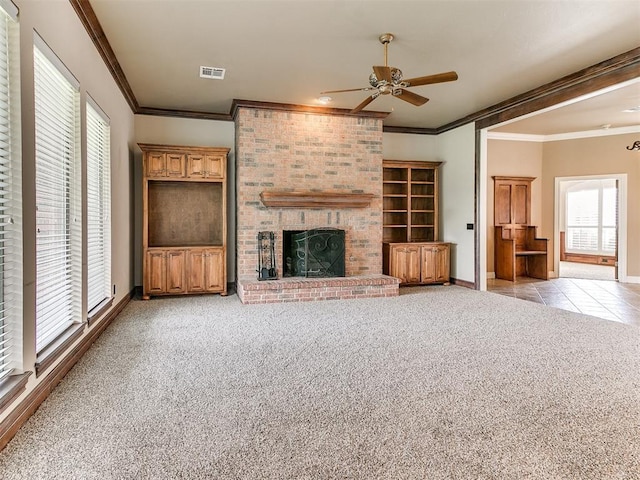 112 Lakeview Ct, Edmond, OK 73003 - unfurnished living room featuring a ceiling fan, light carpet, plenty of natural light, a brick fireplace, and crown molding