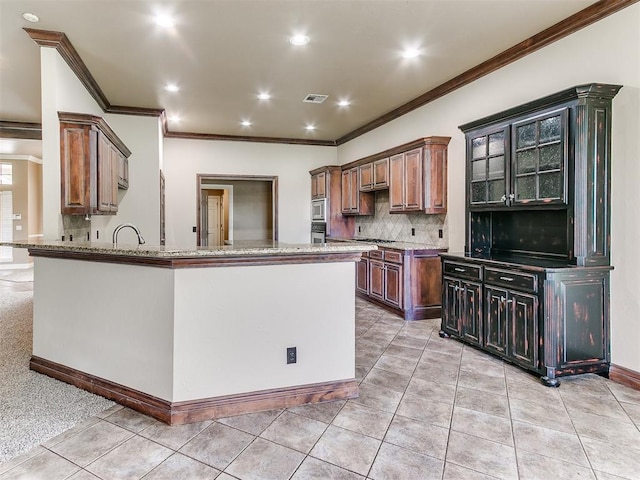 112 Lakeview Ct, Edmond, OK 73003 - kitchen with ornamental molding, light stone countertops, decorative backsplash, light tile patterned floors, and a peninsula