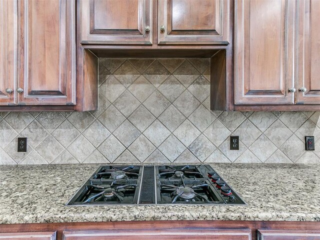 112 Lakeview Ct, Edmond, OK 73003 - kitchen with black gas cooktop, decorative backsplash, and light stone countertops