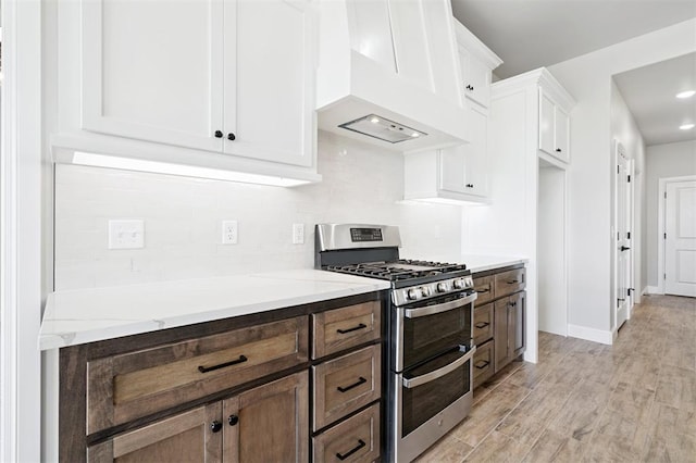 10400 SW 51st St, Mustang, OK 73064 - kitchen with double oven range, premium range hood, backsplash, white cabinets, and light wood-style flooring