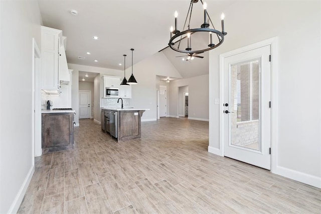 10400 SW 51st St, Mustang, OK 73064 - kitchen featuring built in microwave, a chandelier, open floor plan, light countertops, and white cabinetry