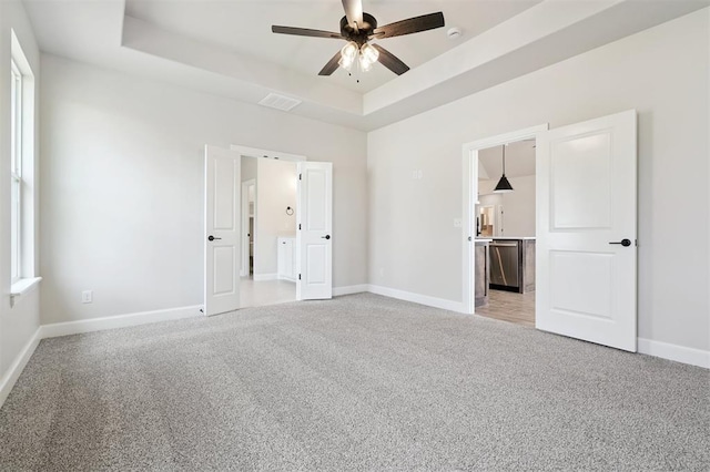 10400 SW 51st St, Mustang, OK 73064 - unfurnished bedroom with light colored carpet, a tray ceiling, and ceiling fan