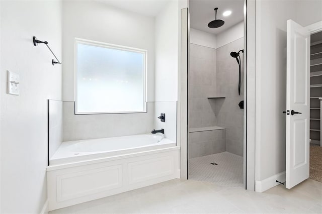 10400 SW 51st St, Mustang, OK 73064 - full bathroom featuring a bath, a shower stall, a walk in closet, and tile patterned flooring