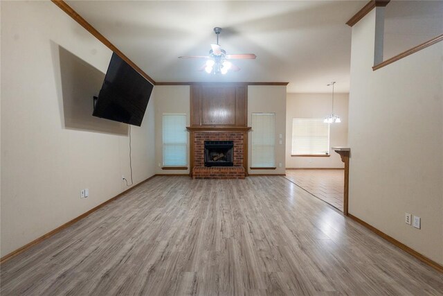 2728 SE 93rd St, Moore, OK 73160 - unfurnished living room featuring a ceiling fan, light wood-type flooring, a fireplace, and crown molding