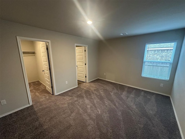 9505 Saddle Dr, Yukon, OK 73099 - unfurnished bedroom with dark colored carpet and a spacious closet
