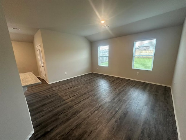 9505 Saddle Dr, Yukon, OK 73099 - empty room featuring dark wood-style flooring and vaulted ceiling