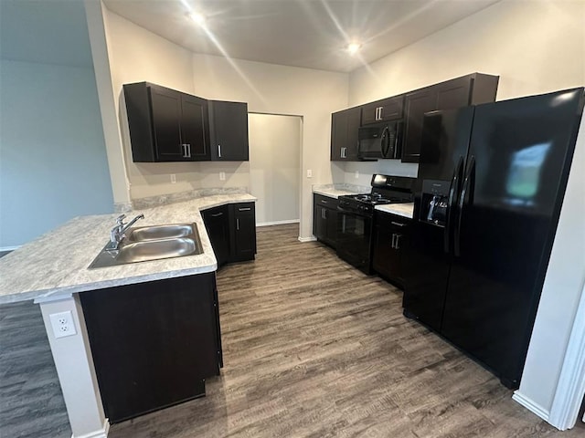 9505 Saddle Dr, Yukon, OK 73099 - kitchen with black appliances, a peninsula, dark wood-style flooring, light countertops, and dark cabinetry