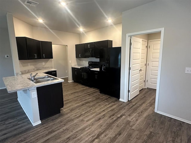 9505 Saddle Dr, Yukon, OK 73099 - kitchen with black appliances, dark cabinetry, a peninsula, dark wood-style flooring, and light countertops