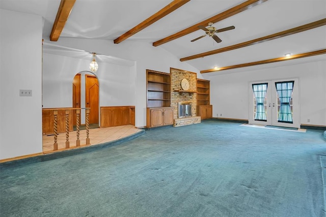 813 Tottingham Rd, Anadarko, OK 73005 - unfurnished living room featuring ceiling fan, carpet, a brick fireplace, french doors, and built in shelves