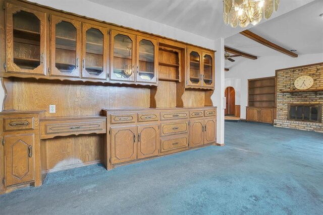 813 Tottingham Rd, Anadarko, OK 73005 - kitchen featuring carpet flooring, glass insert cabinets, a chandelier, brown cabinetry, and arched walkways