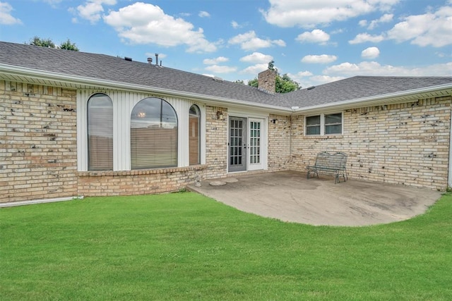 813 Tottingham Rd, Anadarko, OK 73005 - back of house featuring french doors, brick siding, a chimney, and a lawn