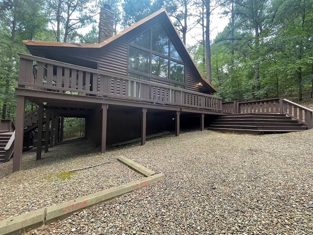 113 Bentwater Rd, Broken Bow, OK 74728 - rear view of house featuring log veneer siding, stairs, a wooden deck, and a chimney