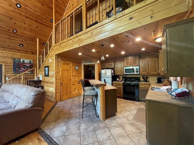 113 Bentwater Rd, Broken Bow, OK 74728 - kitchen featuring black range with electric stovetop, stainless steel microwave, open floor plan, freestanding refrigerator, and light countertops