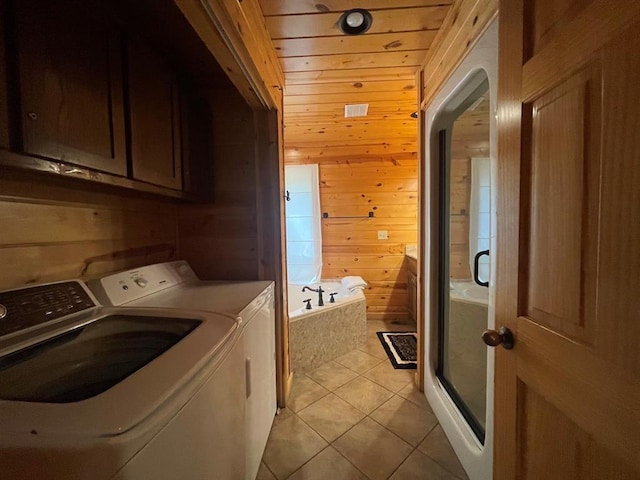 113 Bentwater Rd, Broken Bow, OK 74728 - laundry room featuring washer and clothes dryer, wooden walls, light tile patterned floors, cabinet space, and arched walkways