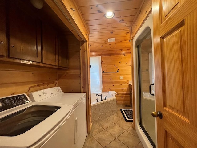 113 Bentwater Rd, Broken Bow, OK 74728 - laundry room with washer and clothes dryer, light tile patterned floors, wooden walls, and cabinet space