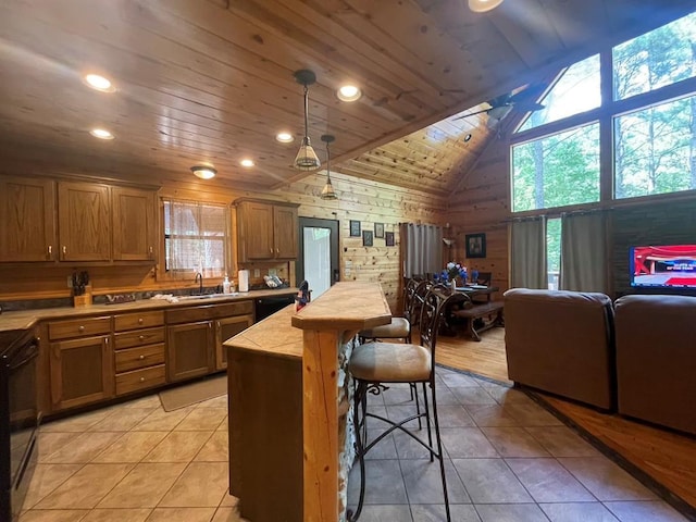 113 Bentwater Rd, Broken Bow, OK 74728 - kitchen with a kitchen bar, light tile patterned floors, wood walls, wood ceiling, and black range oven