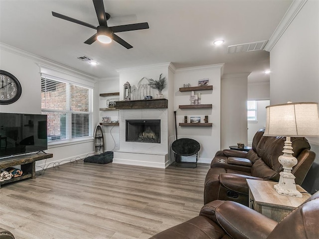11712 Muirfield Ln, Guthrie, OK 73044 - living area with ceiling fan, crown molding, wood finished floors, plenty of natural light, and a fireplace with raised hearth