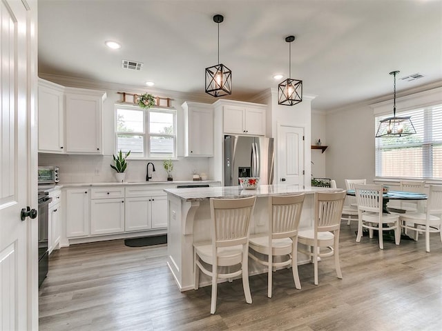 11712 Muirfield Ln, Guthrie, OK 73044 - kitchen featuring stainless steel fridge, crown molding, a center island, healthy amount of natural light, and backsplash