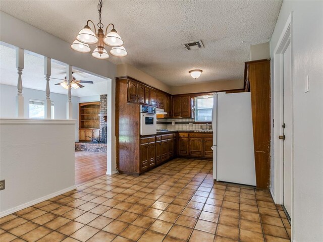 201 S Patterson Dr, Moore, OK 73160 - kitchen with white appliances, a ceiling fan, a textured ceiling, decorative light fixtures, and tasteful backsplash
