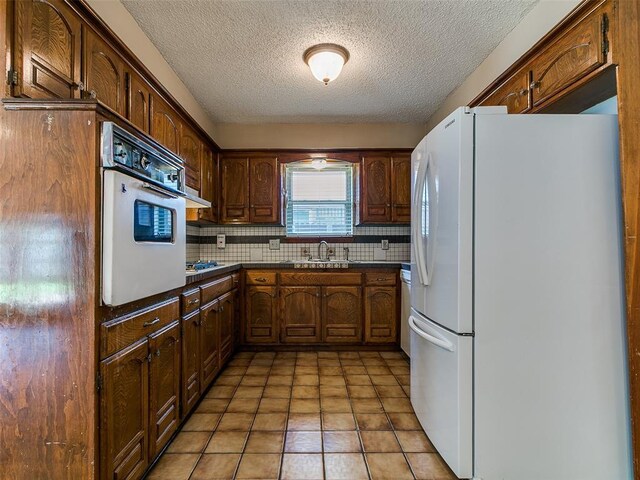 201 S Patterson Dr, Moore, OK 73160 - kitchen with white appliances, dark countertops, tasteful backsplash, and a textured ceiling