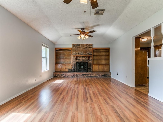 201 S Patterson Dr, Moore, OK 73160 - unfurnished living room featuring a ceiling fan, a textured ceiling, wood finished floors, a brick fireplace, and lofted ceiling