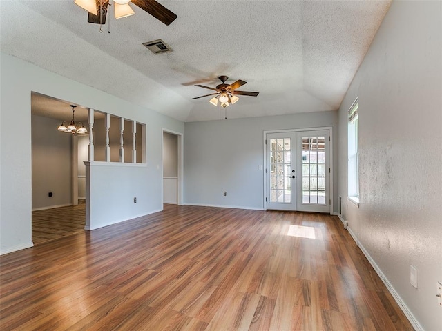 201 S Patterson Dr, Moore, OK 73160 - empty room with a ceiling fan, wood finished floors, lofted ceiling, a textured ceiling, and a chandelier