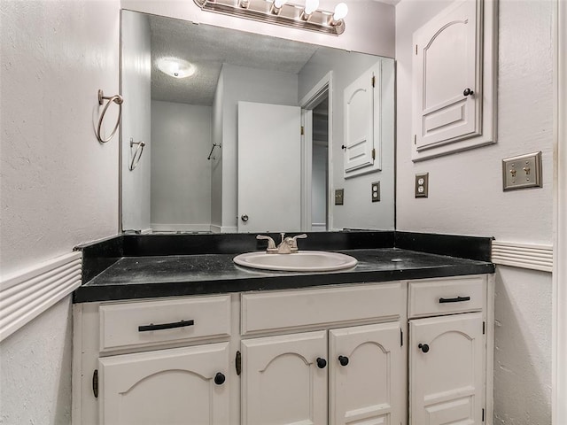 201 S Patterson Dr, Moore, OK 73160 - bathroom with vanity, a textured ceiling, and a textured wall