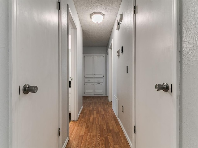 201 S Patterson Dr, Moore, OK 73160 - hall featuring a textured ceiling and wood finished floors