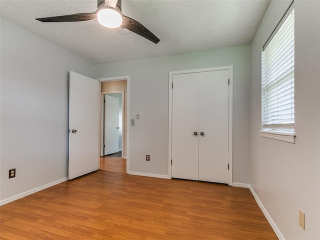 201 S Patterson Dr, Moore, OK 73160 - unfurnished bedroom featuring light wood-style floors, a textured ceiling, ceiling fan, and a closet