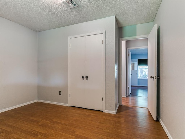 201 S Patterson Dr, Moore, OK 73160 - unfurnished bedroom featuring wood finished floors, a textured ceiling, and a closet