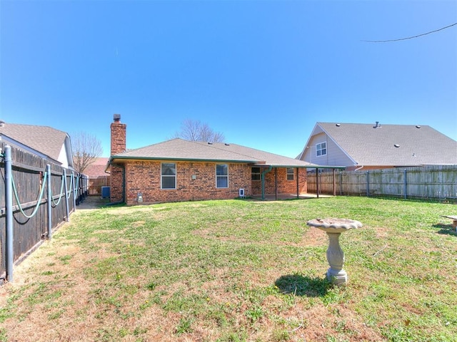 201 S Patterson Dr, Moore, OK 73160 - rear view of property with a fenced backyard, a chimney, and brick siding