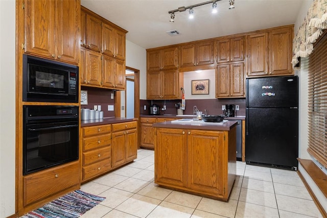 1748 Logans Run, Chandler, OK 74834 - kitchen with black appliances, brown cabinets, light tile patterned flooring, a kitchen island, and rail lighting
