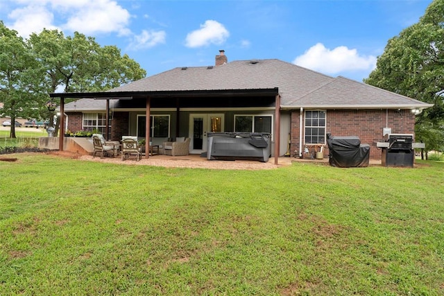 1748 Logans Run, Chandler, OK 74834 - back of property with a hot tub, brick siding, a patio, and a lawn
