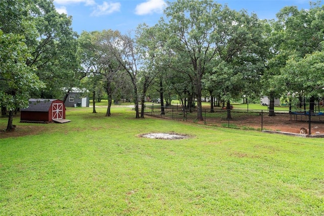 1748 Logans Run, Chandler, OK 74834 - view of yard with a trampoline, a storage shed, and view of wooded area