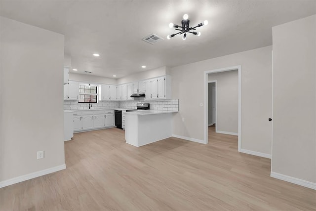 1712 N 4th St, Sayre, OK 73662 - kitchen with range, a peninsula, white cabinets, light countertops, and black dishwasher
